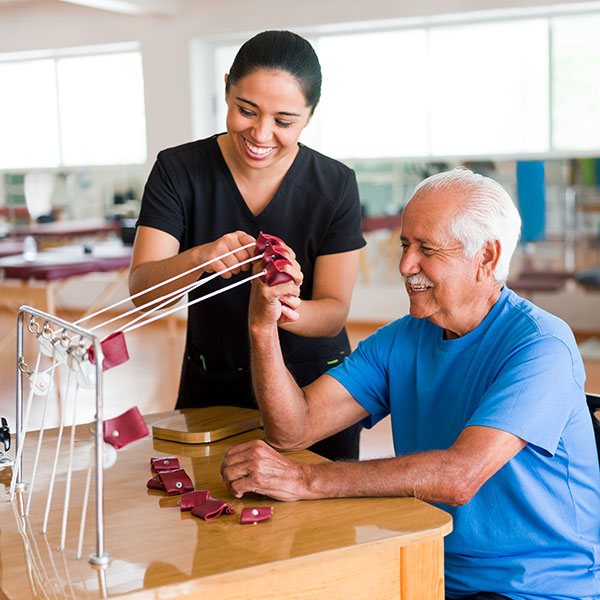 Physical therapist working on arm strength with patient