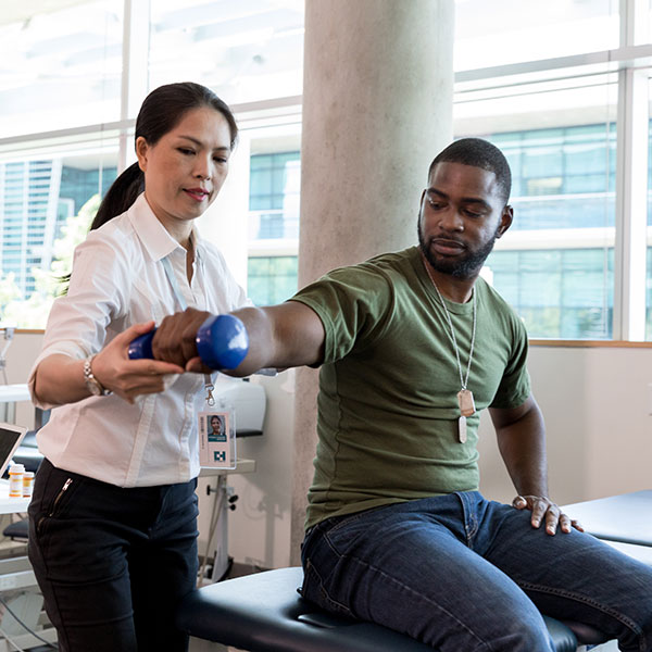 Physical therapist working on arm strength with patient