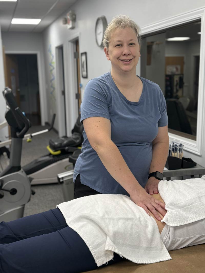 Therapist performing hands-on treatment on a patient lying on a table in a clinic